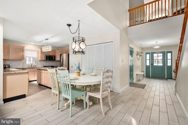 dining space featuring plenty of natural light, a chandelier, sink, and light hardwood / wood-style flooring