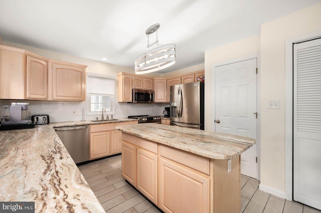 kitchen featuring light brown cabinetry, sink, decorative light fixtures, a center island, and appliances with stainless steel finishes