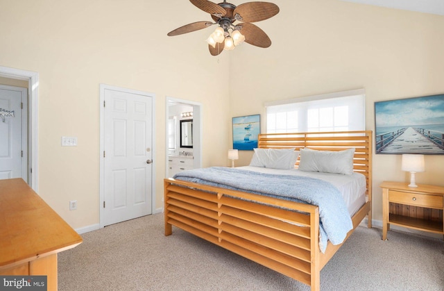 bedroom with connected bathroom, ceiling fan, a high ceiling, and carpet flooring