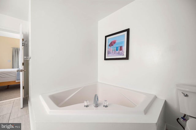 bathroom featuring a tub to relax in and toilet