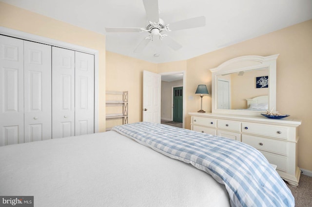 bedroom with ceiling fan, carpet floors, and a closet