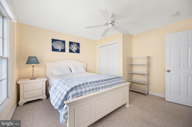 carpeted bedroom featuring a closet and ceiling fan