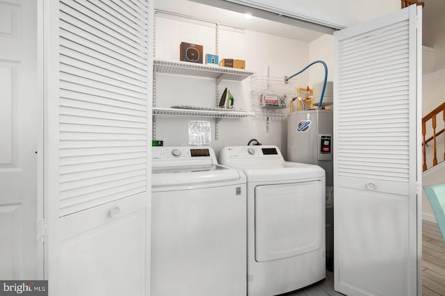 clothes washing area with separate washer and dryer and water heater