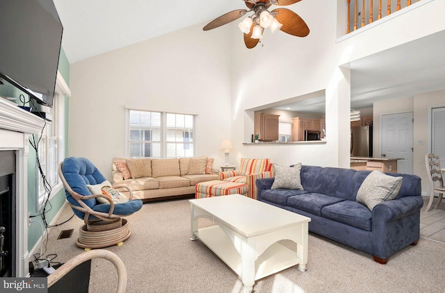 carpeted living room with high vaulted ceiling and ceiling fan