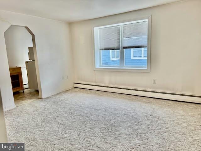 carpeted spare room with baseboard heating