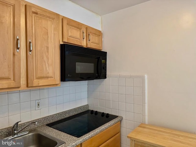 kitchen with tasteful backsplash, sink, and black appliances