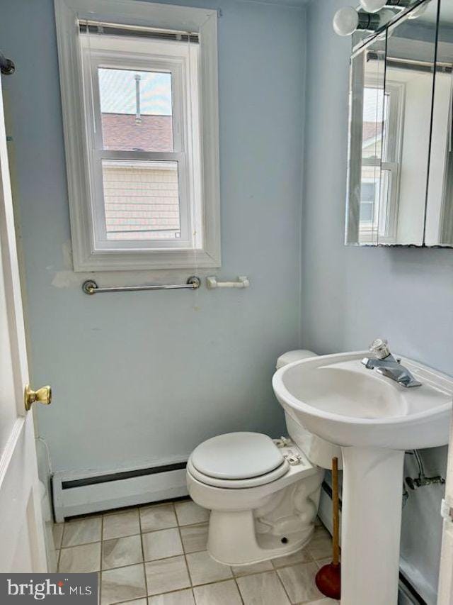 bathroom featuring a baseboard heating unit, tile patterned floors, and toilet