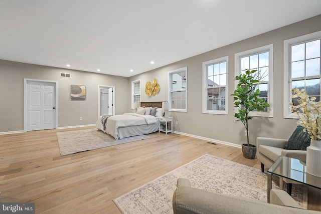 bedroom featuring multiple windows and light hardwood / wood-style flooring