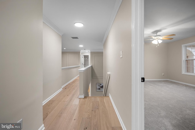 corridor featuring ornamental molding and light wood-type flooring