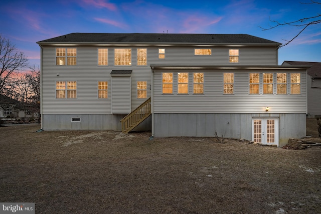 back house at dusk featuring french doors