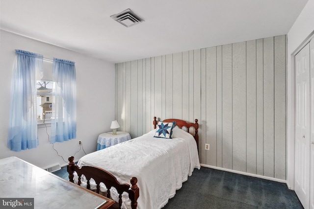 carpeted bedroom with wood walls