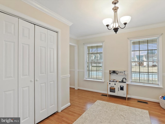 interior space with a notable chandelier, ornamental molding, and hardwood / wood-style floors