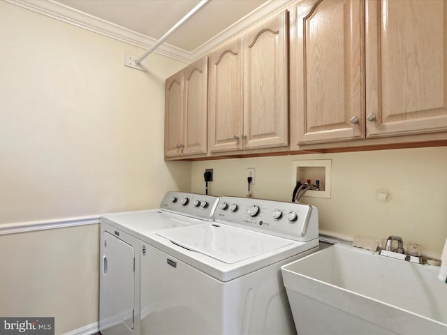 laundry area with sink, cabinets, washing machine and dryer, and ornamental molding