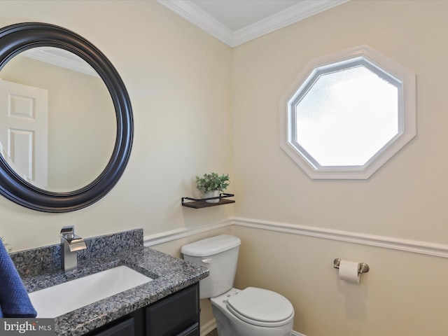 bathroom featuring toilet, vanity, and ornamental molding