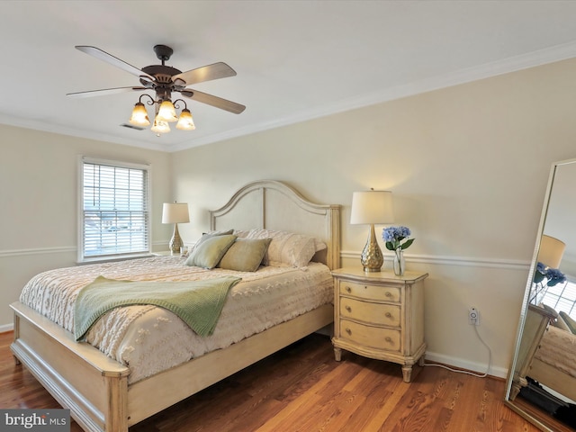 bedroom featuring ceiling fan, dark wood-type flooring, and crown molding