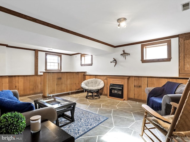 living room featuring a fireplace, ornamental molding, and wood walls