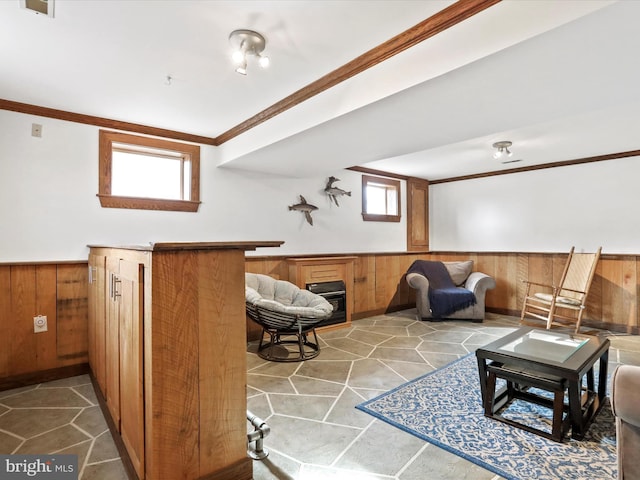 interior space featuring a fireplace, ornamental molding, light tile patterned flooring, and wood walls