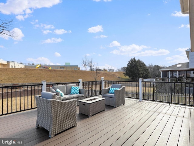 wooden terrace featuring an outdoor living space with a fire pit