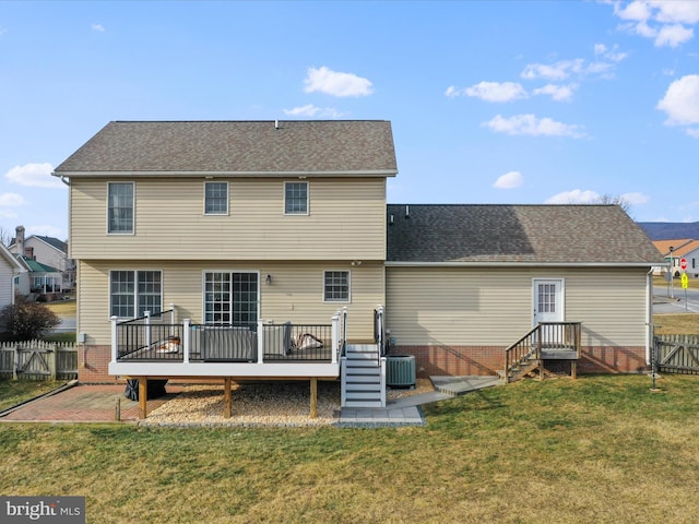 back of house featuring central air condition unit, a wooden deck, and a yard