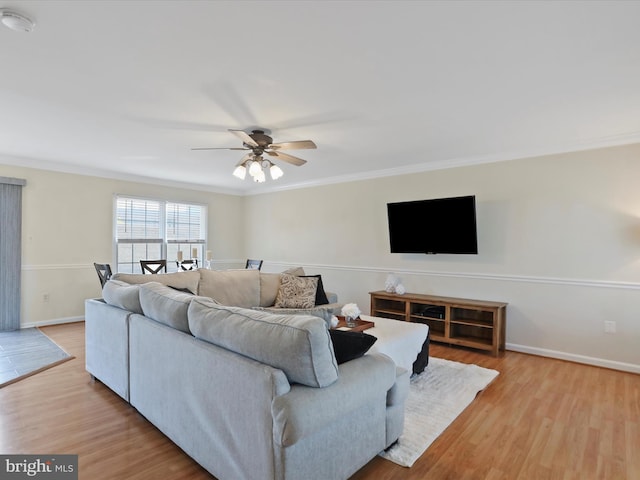 living room with ceiling fan, ornamental molding, and light hardwood / wood-style floors