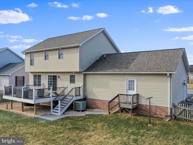 rear view of property featuring cooling unit, a yard, and a wooden deck