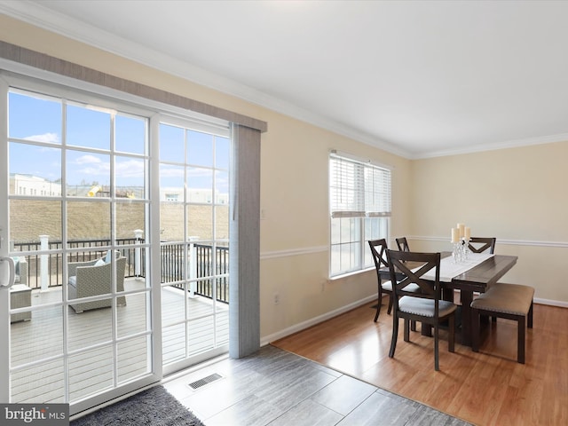 dining area with hardwood / wood-style flooring and crown molding