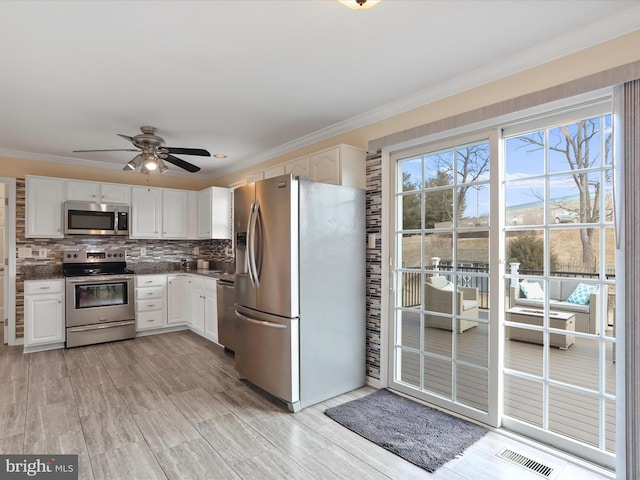 kitchen featuring crown molding, white cabinetry, and stainless steel appliances