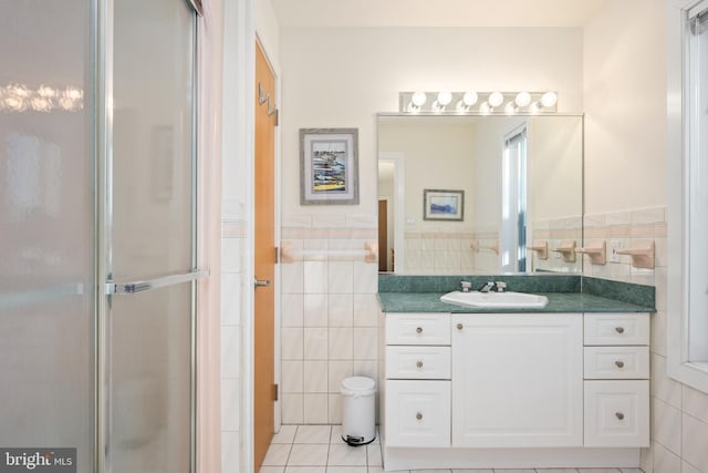 bathroom featuring tile walls, vanity, a shower with shower door, and tile patterned flooring