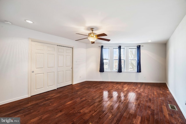 unfurnished bedroom featuring dark hardwood / wood-style flooring, a closet, and ceiling fan