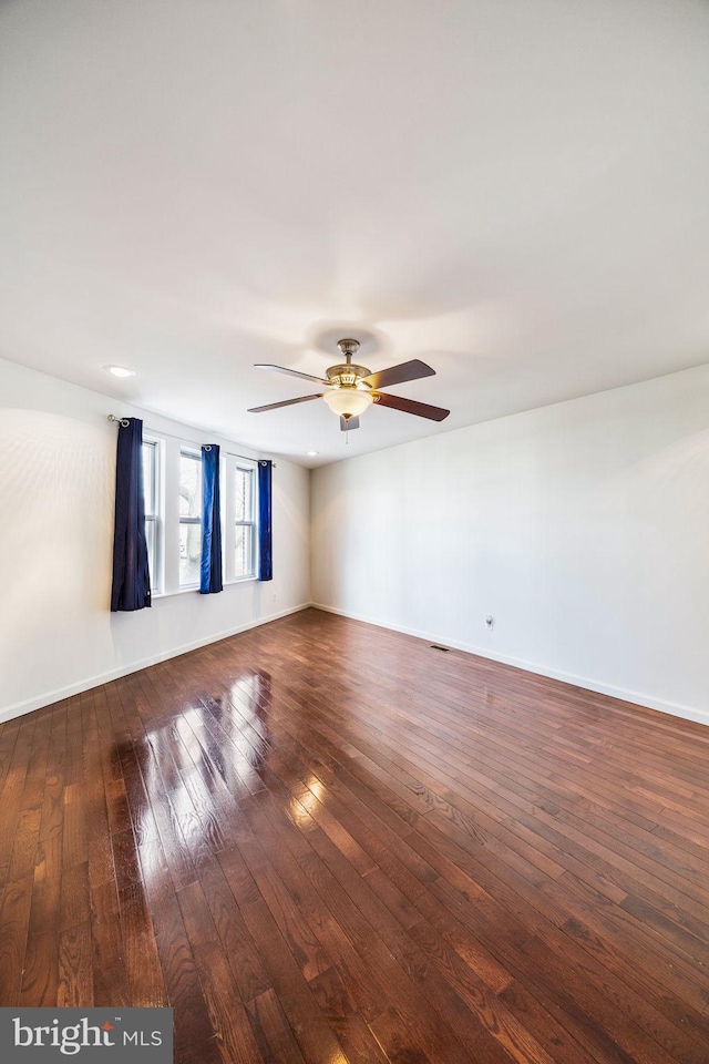 empty room with ceiling fan and dark hardwood / wood-style floors