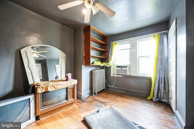 interior space featuring hardwood / wood-style floors, radiator heating unit, and ceiling fan