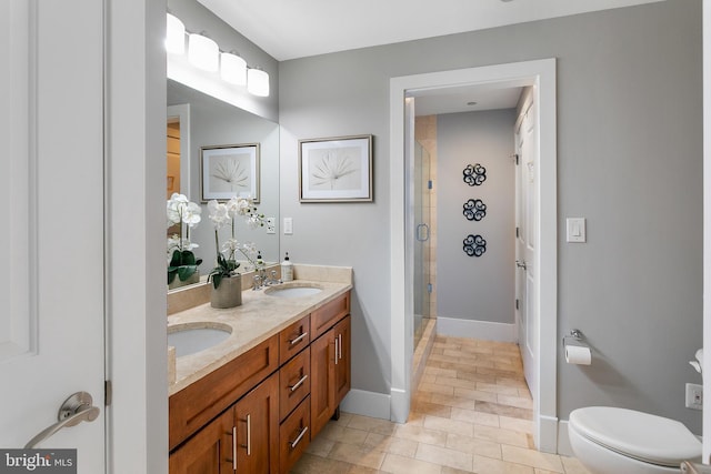 bathroom featuring vanity, a shower with door, and toilet