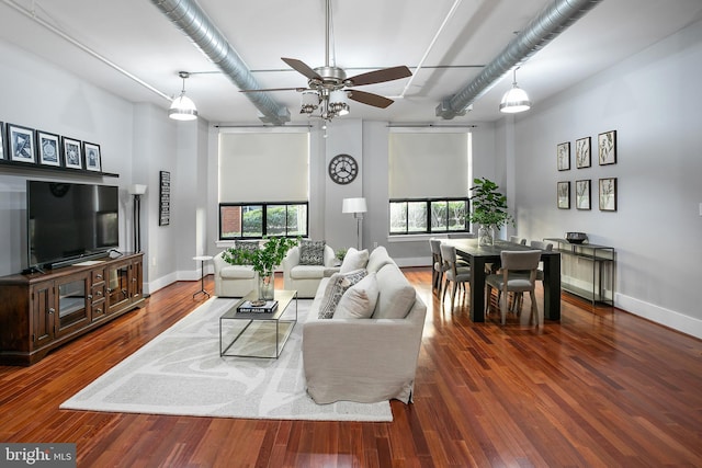 living room featuring ceiling fan and dark hardwood / wood-style floors