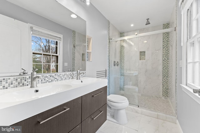 bathroom with vanity, toilet, an enclosed shower, and decorative backsplash