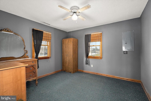 unfurnished bedroom featuring electric panel, baseboards, visible vents, a textured ceiling, and dark carpet