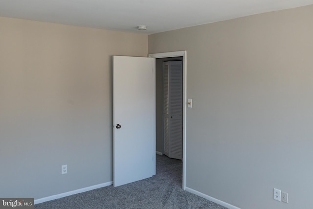 spare room featuring baseboards and carpet