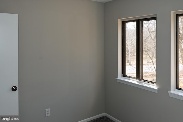 empty room featuring baseboards and plenty of natural light