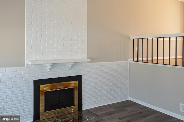 interior details with a brick fireplace and wood finished floors