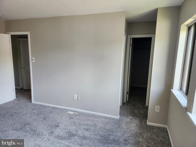 carpeted spare room with baseboards and visible vents