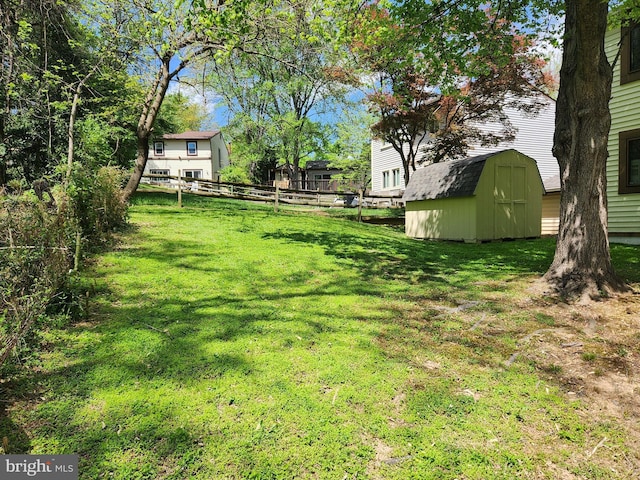view of yard with a storage shed, fence, and an outbuilding
