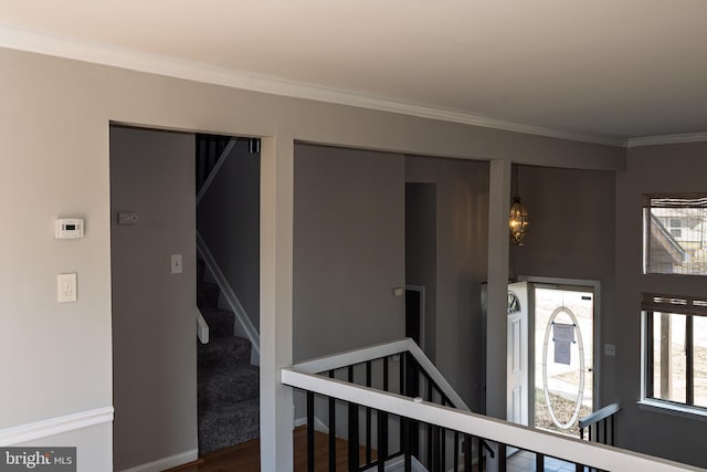 hall featuring wood finished floors, an upstairs landing, baseboards, and ornamental molding