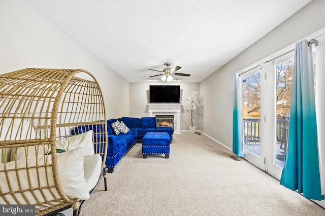 carpeted living room with ceiling fan and a textured ceiling