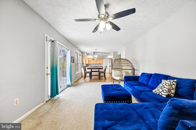 carpeted living room with ceiling fan and a textured ceiling