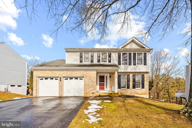 view of property with a garage and a front lawn