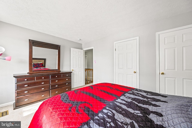 bedroom with a textured ceiling and carpet