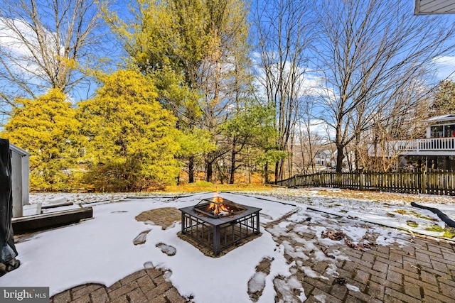 snow covered patio featuring an outdoor fire pit