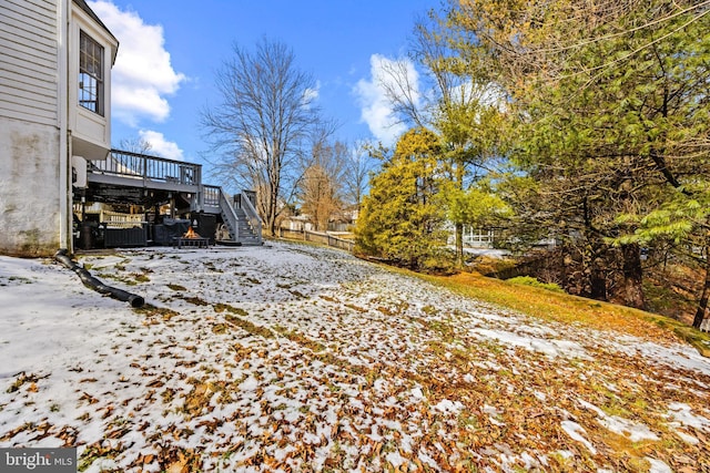 yard layered in snow featuring a wooden deck