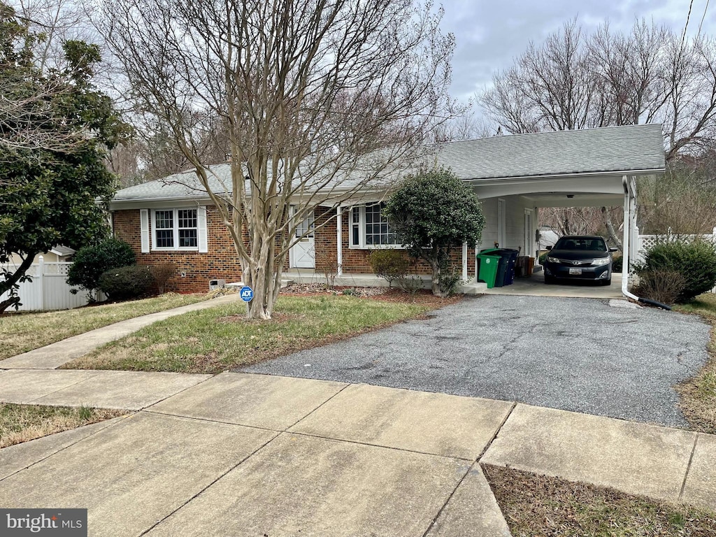 ranch-style house featuring aphalt driveway, crawl space, fence, a carport, and brick siding