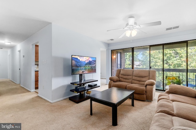 living room featuring ceiling fan, light colored carpet, and a healthy amount of sunlight