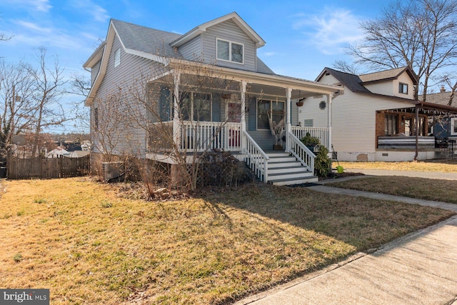 bungalow-style house featuring fence, a front lawn, and a porch